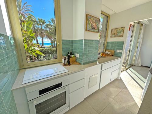 La salle de bains est pourvue d'un lavabo et offre une vue sur l'océan. dans l'établissement Cosy Sea Front Garden Nice, à Nice