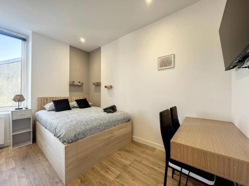 une chambre avec un lit, un bureau et une table dans l'établissement Studio Croix Saint Lambert - Proche gare, à Saint-Brieuc