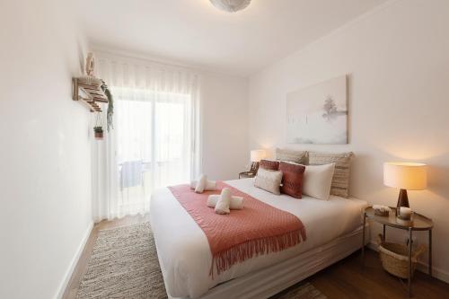 Un dormitorio blanco con una cama grande y una ventana. en SeaBreeze Residence, en Atouguia da Baleia
