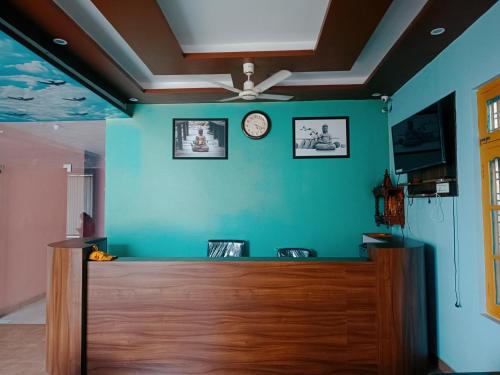 a green wall with a ceiling fan and a counter at Ratan guest house in Narendranagar