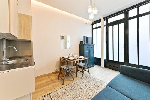 - une cuisine et un salon avec un canapé bleu et une table dans l'établissement Duplex agréable et comfortable dans le 9ème, à Paris