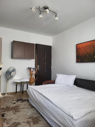 a bedroom with a bed and a painting on the wall at Penthouse Marasti in Cluj-Napoca