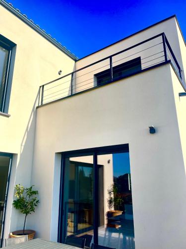 une maison blanche avec de grandes portes coulissantes en verre dans l'établissement Maison entière Uzès 3 chambres, à Uzès
