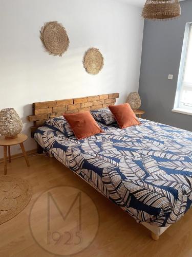 a bedroom with a bed with a wooden headboard and pillows at Maison 1925, Méricourt 62 in Méricourt