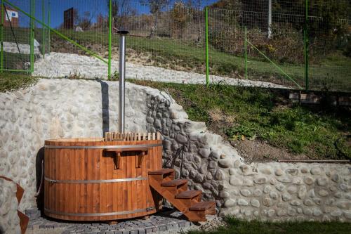 a wooden barrel and stairs next to a stone wall at Pensiunea Szilas Panzió in Păuleni