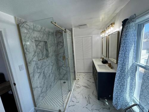 a bathroom with a walk in shower and a sink at The Captains Perch in Stonington