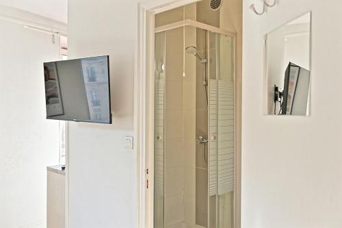 La salle de bains est pourvue d'une douche et d'une télévision murale. dans l'établissement Studio cosy et lumineux proche de Nation Voltaire, à Paris