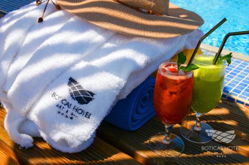 a towel sitting on a table next to two drinks at Boticas Hotel Art & SPA in Boticas