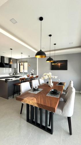 a kitchen and dining room with a wooden table and chairs at Zensiri Brand New Luxury Pool Villa in Pattaya