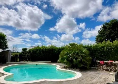- une piscine dans une cour avec un ciel bleu dans l'établissement La rêverie, à Plouézec