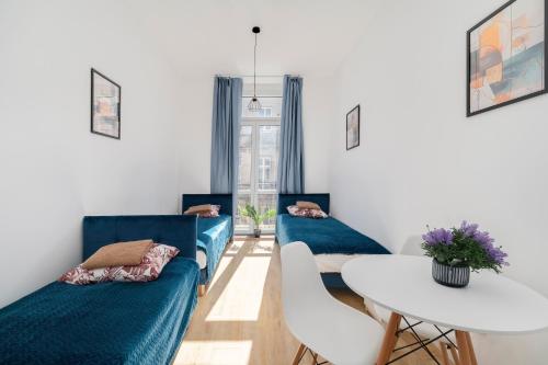a living room with two blue couches and a table at Centrum 5 Łódź 7 Próchnika 21 in Łódź