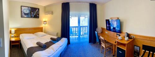 a hotel room with a bed and a desk and a television at LAS SŁUPSKI APARTAMENTY PREMIUM Wifi Netflix Smart TV50 Wysoka Jakość za Niską Cenę Zapraszamy in Słupsk