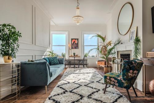 a living room with a blue couch and chairs at The Wellington - style, charm and sea views in Ramsgate
