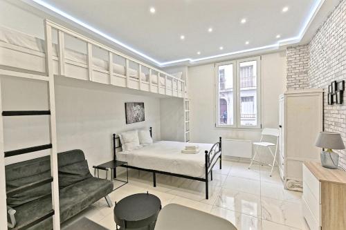 une chambre avec un lit, un canapé et une chaise dans l'établissement Studio Cosy Proche de Montmartre Charme du 18e, à Paris