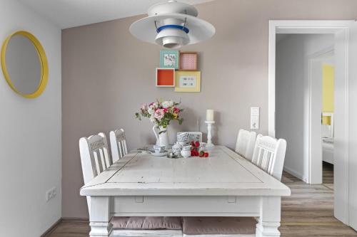 a white dining room with a white table and chairs at Landhaus Hohe Luft in Steinberg