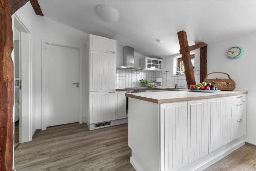 a kitchen with white cabinets and a counter top at Landhaus Hohe Luft in Steinberg