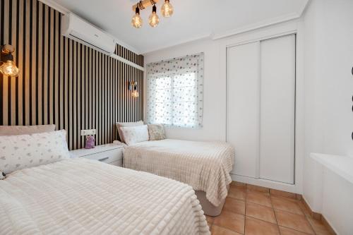 sypialnia z dwoma łóżkami i oknem w obiekcie CB Living - First line detached house, Cabo Roig w mieście Orihuela