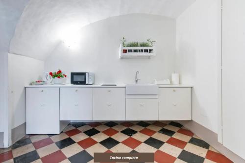 a white kitchen with a sink and a microwave at Le Stanze del Poeta Apartment - Lecce Selection in Lecce