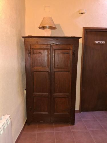 a wooden cabinet in a room with a lamp at Cal Tonico Rural in Ribes de Freser