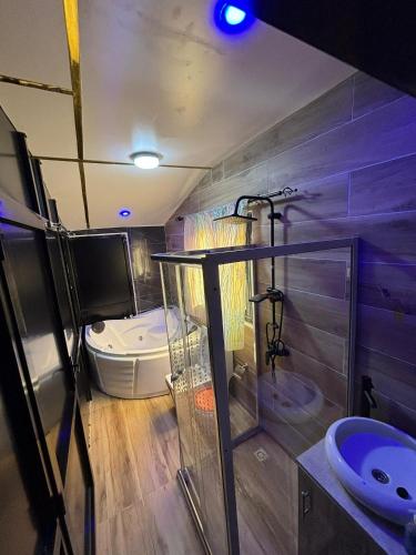 a bathroom with a tub and a toilet and a sink at Studio avec Jacuzzi Aeroport AIBD in Déni Diarke