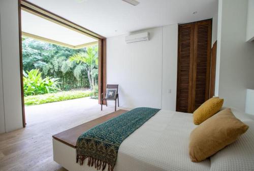 アナポイマにあるClassy 4BR Villa with Pool at Mesa de Yeguasの大きなベッドと大きな窓のある寝室