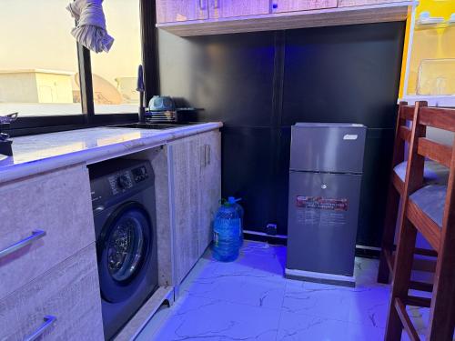 a kitchen with a washing machine and a washer at Studio avec Jacuzzi Aeroport AIBD in Déni Diarke
