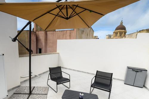 a patio with two chairs and an umbrella on a roof at La home di Antonio in Marsala