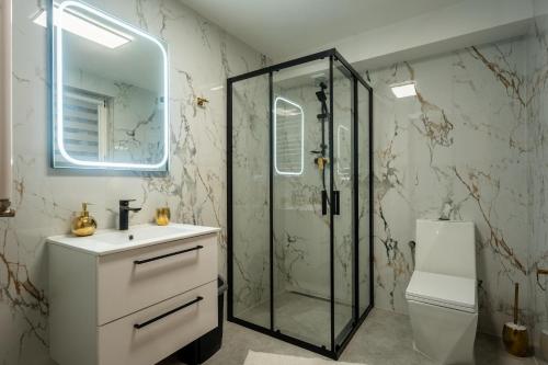 een badkamer met douche, wastafel en toilet bij Willa Arkadia in Pobierowo