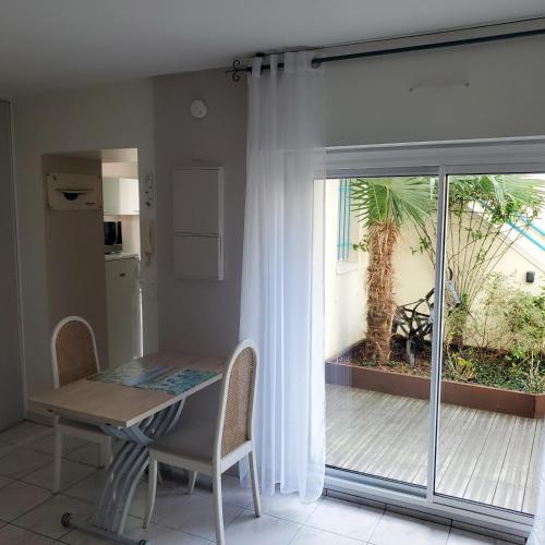d'une salle à manger avec une table et une porte coulissante en verre. dans l'établissement Cosy Flat - Terrasse - Parking - 40m2, à La Rochelle