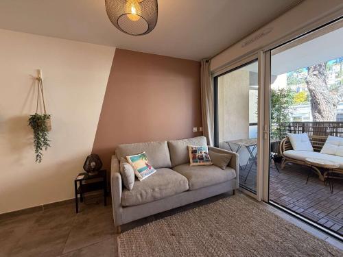 d'un salon avec un canapé et un balcon. dans l'établissement T2 centre ville/Plage/Commerces/Clim, au Lavandou