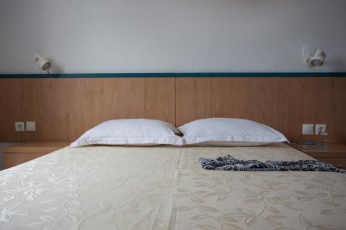 a bedroom with a large bed with two pillows at SUN -RISE in Perissa
