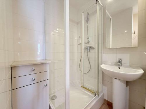 une salle de bain blanche avec une douche et un lavabo dans l'établissement T3- Proche plages et commerces, à Bormes-les-Mimosas