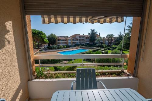 d'un balcon avec une table et des chaises et une vue sur la piscine. dans l'établissement T2 cabine rénové/Piscine/Clim/commerces, au Lavandou