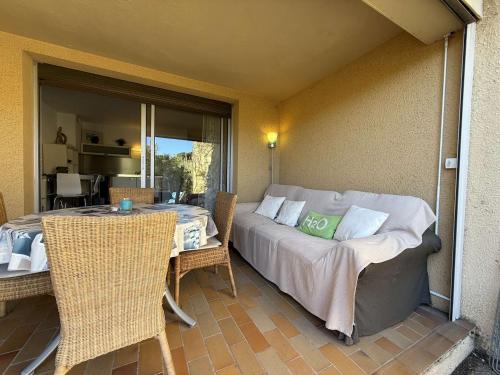 une chambre avec un lit, une table et des chaises dans l'établissement T2 en rez de jardin , proche plage de St Clair et commerces, au Lavandou