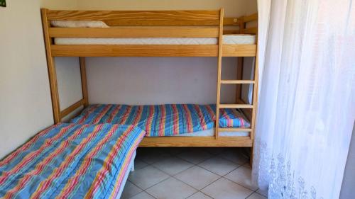une chambre avec un lit superposé avec une échelle dans l'établissement T2- Parking- Plages- Commerces, à Bormes-les-Mimosas