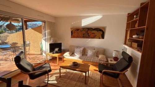 un salon avec un canapé, des chaises et une télévision dans l'établissement Paisible T2- PLages et Commerces, au Lavandou
