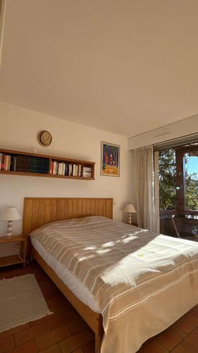 une chambre avec un grand lit et une fenêtre dans l'établissement Paisible T2- PLages et Commerces, au Lavandou