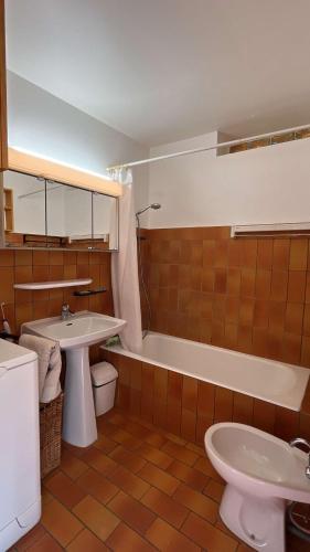 une salle de bain avec un lavabo, des toilettes et une baignoire dans l'établissement Paisible T2- PLages et Commerces, au Lavandou