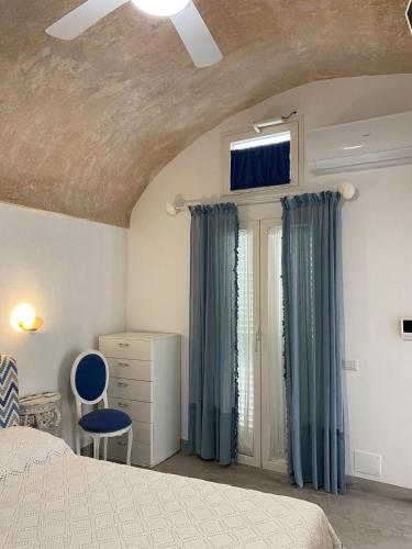 a bedroom with blue curtains and a bed and a window at Casa Manù in Gallipoli