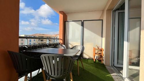 un balcon avec une table et des chaises sur un balcon dans l'établissement T3 spacieux- Clim- Piscine, à Bormes-les-Mimosas