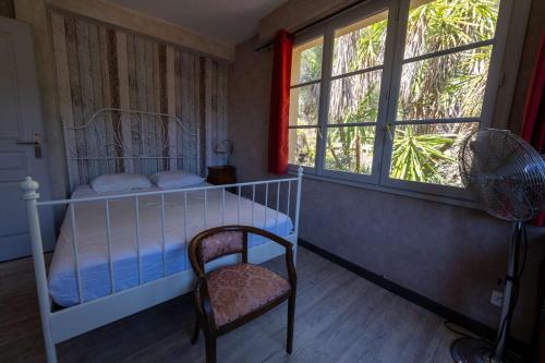 une chambre avec un lit, une chaise et une fenêtre dans l'établissement T4 , Jardin arboré et plages à moins de 5 min à pieds, à Bormes-les-Mimosas