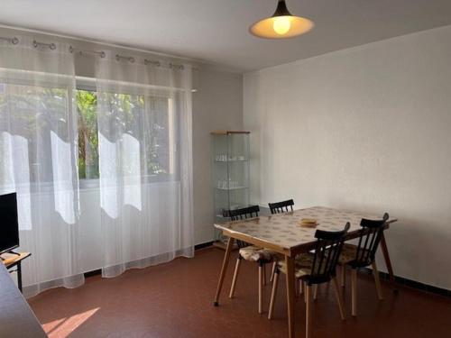 une salle à manger avec une table et des chaises et une fenêtre dans l'établissement T2- Piscine- Plages- Commerces, au Lavandou