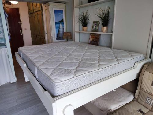 Ce lit se trouve dans un dortoir doté d'un matelas blanc. dans l'établissement Studio- Piscine- Clim- Plages, à Bormes-les-Mimosas