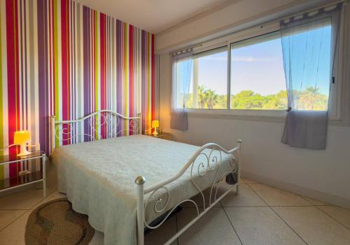 une chambre avec un lit et une grande fenêtre dans l'établissement T2 pied dans l'eau- Vue mer- Proche commerces, au Lavandou