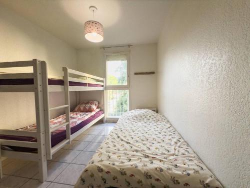 une chambre avec deux lits superposés et une fenêtre dans l'établissement T3 spacieux - climatisé - commerces - plages, au Lavandou