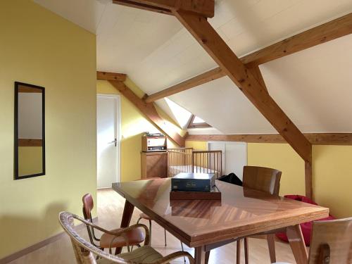 une salle à manger avec une table et des chaises en bois dans l'établissement L'Escale - Family home, à Granville