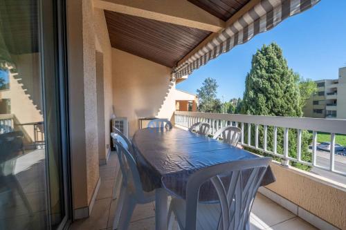 un porche avec une table et des chaises sur un balcon dans l'établissement Superbe T3 Clim / Piscine / commerces et plages., au Lavandou