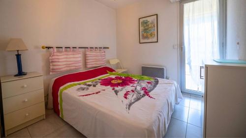 une chambre avec un lit avec une fleur dessus dans l'établissement Superbe T3 Clim / Piscine / commerces et plages., au Lavandou