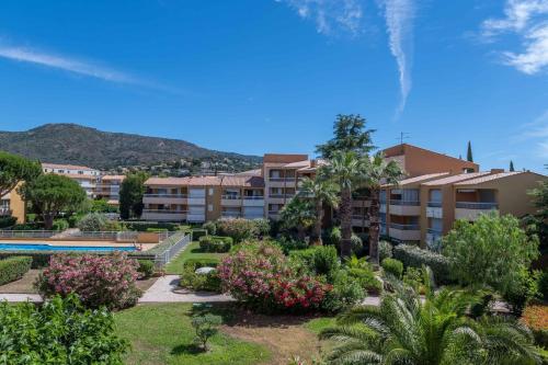 un complexe avec un jardin et une piscine dans l'établissement Superbe T3 Clim / Piscine / commerces et plages., au Lavandou