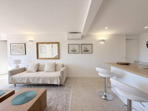 a white living room with a couch and a table at Magnifique maison avec pisicne in Le Lavandou